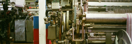 Industrial loom weaving fabric onto a roll in a textile mill
