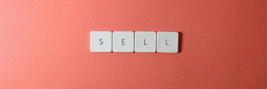 Keyboard keys arranged to spell the word SELL on a coral background