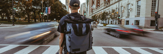 Commuter waiting at a city crossing with a backpack on
