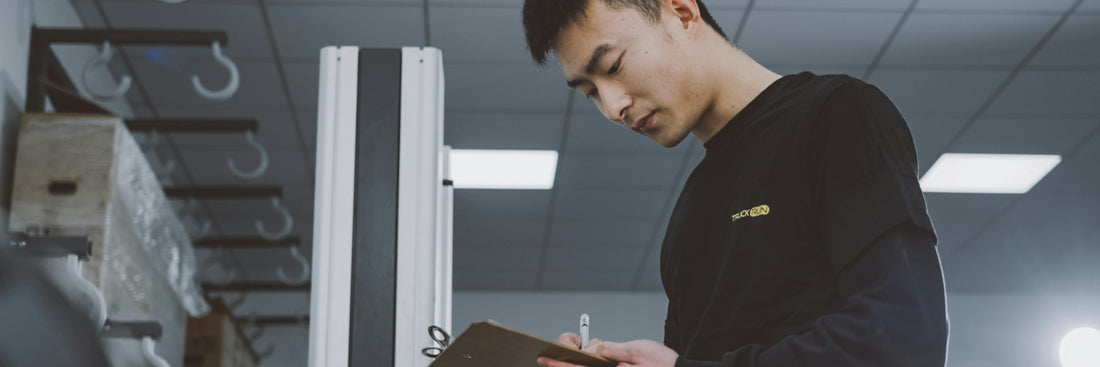 Inspector with a clipboard checking stock on a factory floor