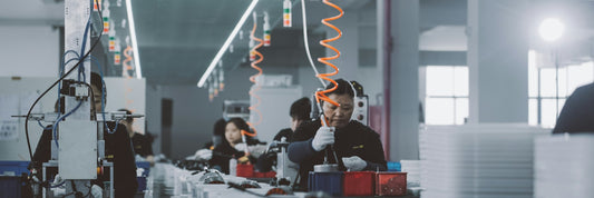 Workers on a production line inside a manufacturing plant
