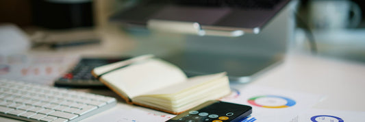 Financial charts and a calculator spread across a desk