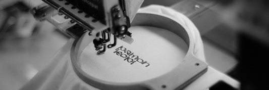 Industrial embroidery machine stitching a logo into fabric